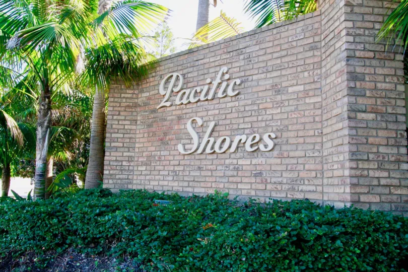 Pacific Shores stone sign with palm trees and bushes.
