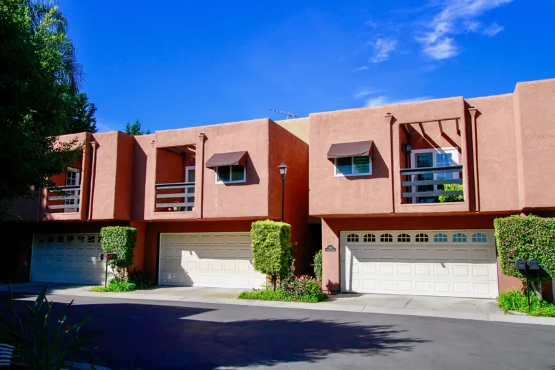 Row of Pacific Terrace homes with a garage and balcony on a sunny day.