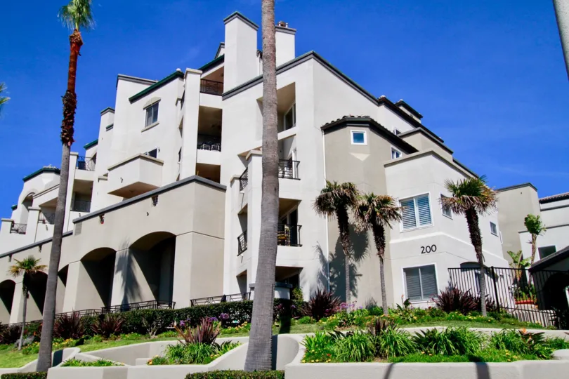 A BIG HOUSE ALONE WITH THREE FLOORS AND MORE BALCONY IN THE APARTMENTS AND MORE TREES AND PLANTS IN FRONT OF THE APARTMENTS AT THE MORNING TIME