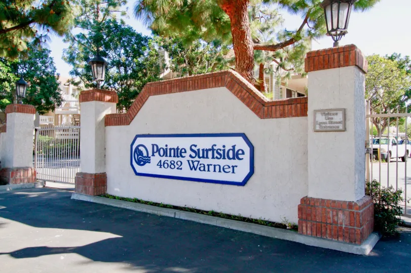 Pointe Surfside sign with gates on either side on a sunny day.