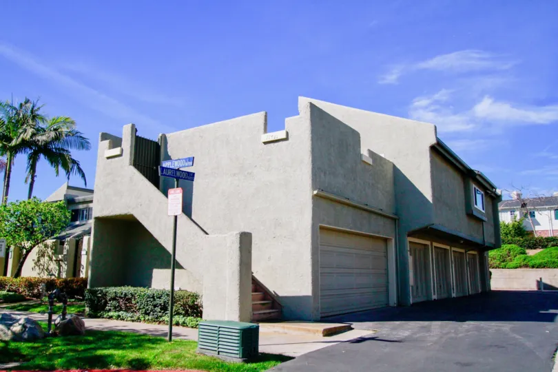 Sea Breeze Village building with a garage and staircase on a sunny day.