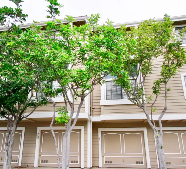 Seabridge Townhomes beige building with trees on a cloudy day.