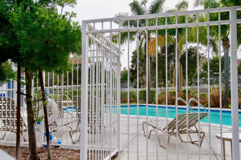 A cloudy day by the pool and palm trees in Huntington Beach with lawn chairs