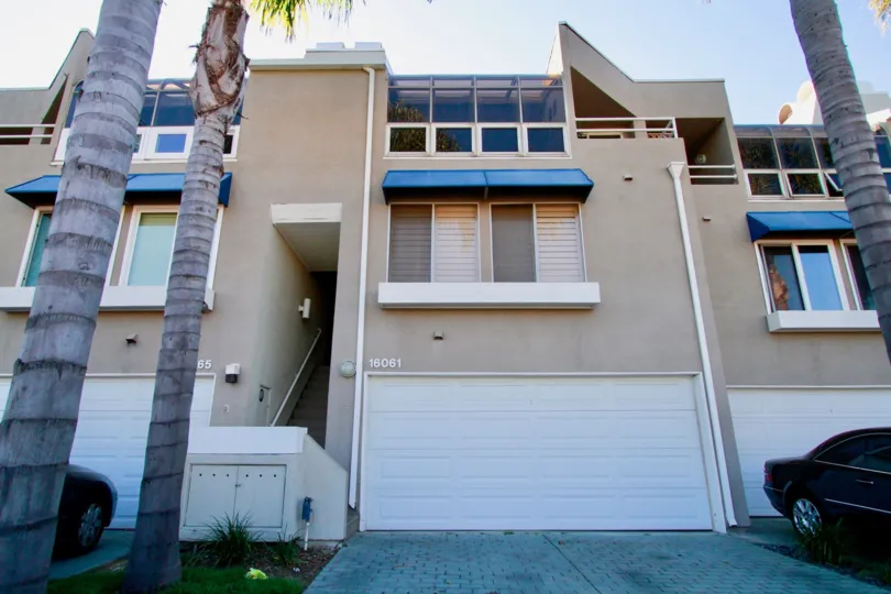 A HOUSE WITH TWO FLOORS AND SOME WINDOWS AVAILABLE AT THE APARTMENTS AND SOME TREES ALSO AT THE FRONT OF THE BUILDING