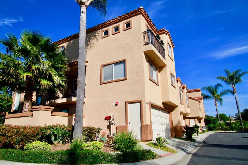 Seacliff Palms apartment buildings with palm trees and bushes on a sunny day.
