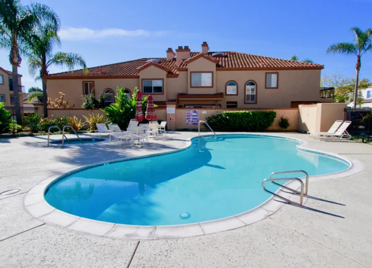 Seacliff Palms Huntington Beach California building brown color paint front big tree attached view to sky front big swimming pool steps and bench attached