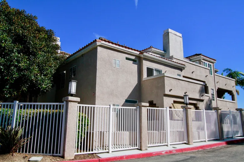 A large white metal fene surrounded a housing building inside Seaport I in Huntington Beach CA