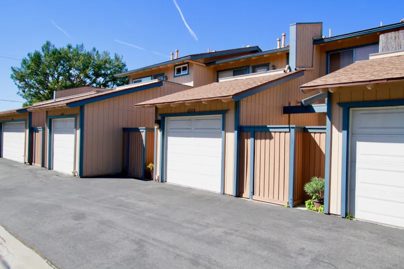 Seascape buildings with garages and fences on a sunny day.
