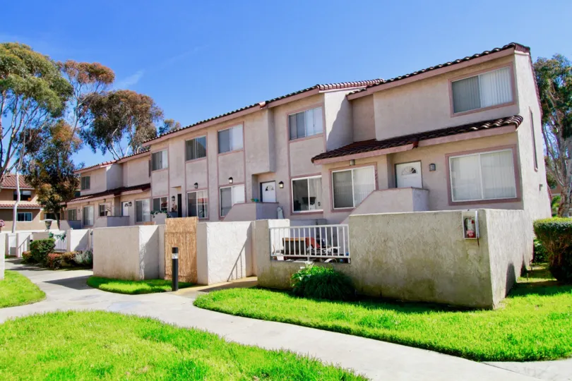 Multi level residential building with green grass on front yard in Seaside Village community.
