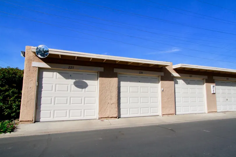 Row of Seaspray garages with a security camera on a sunny day.