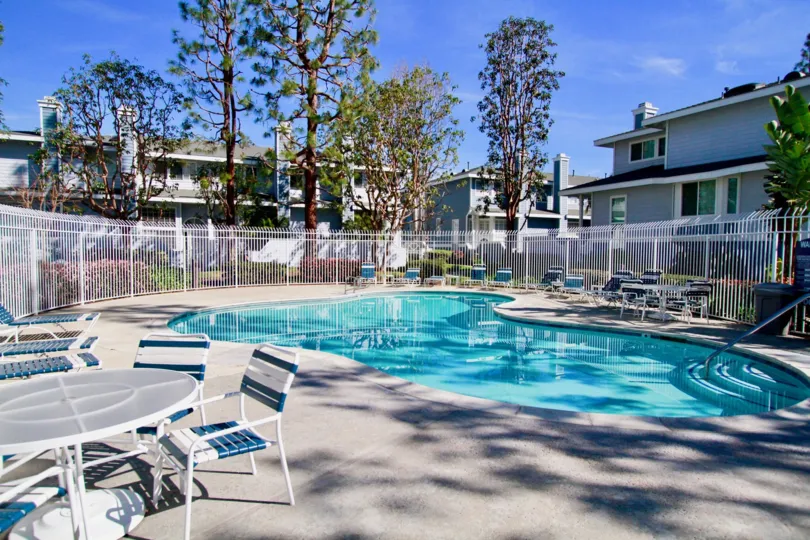 Seawind Cove pool with deck chairs and tables on a sunny day.