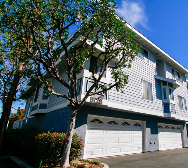 Seawind Cove three story building with trees on the left on a sunny day.