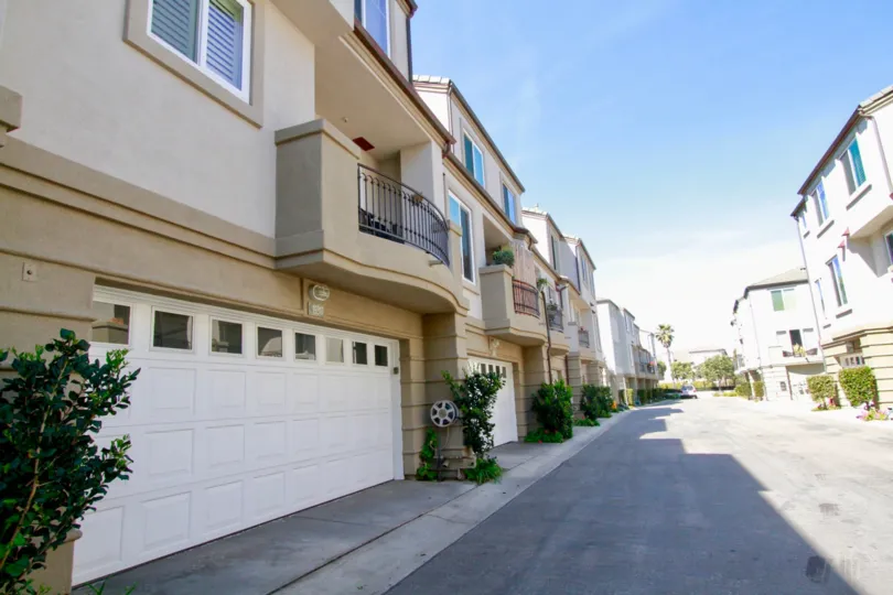 Surfcrest Huntington Beach California house is very quit light biscuts color and brown balcony attached near small tree