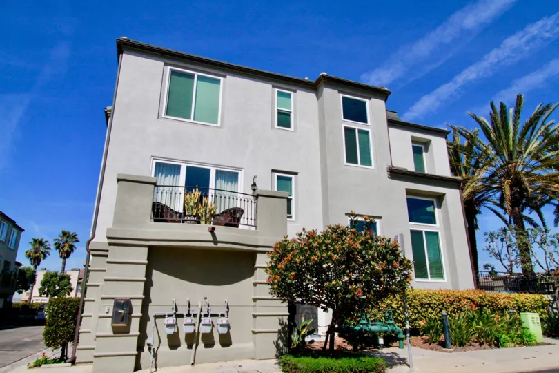 The gray stucco of the Surfcrest community stands out against the blue sky