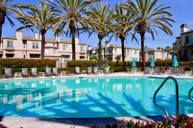 A sunny day in the Surfcrest with swimminpool, chair, trees and look like resort.