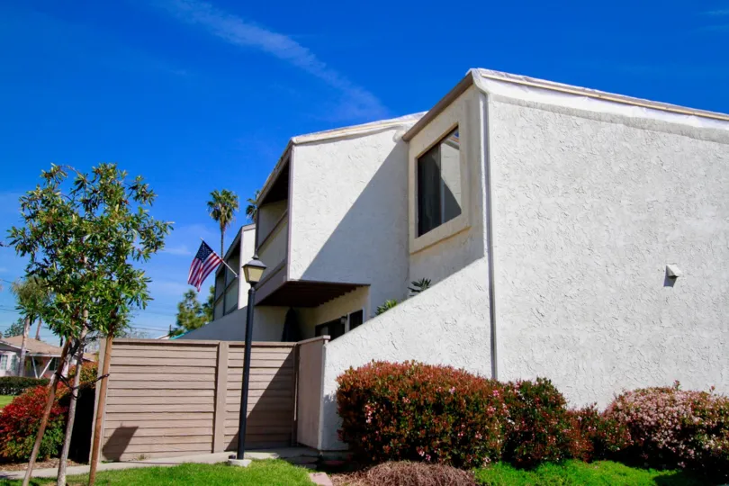 Tamarack Village building with a fence and a flag on a sunny day.