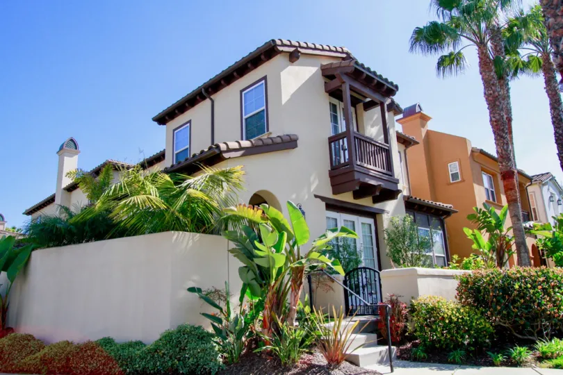 The Waterfront homes with a fence and palm trees.