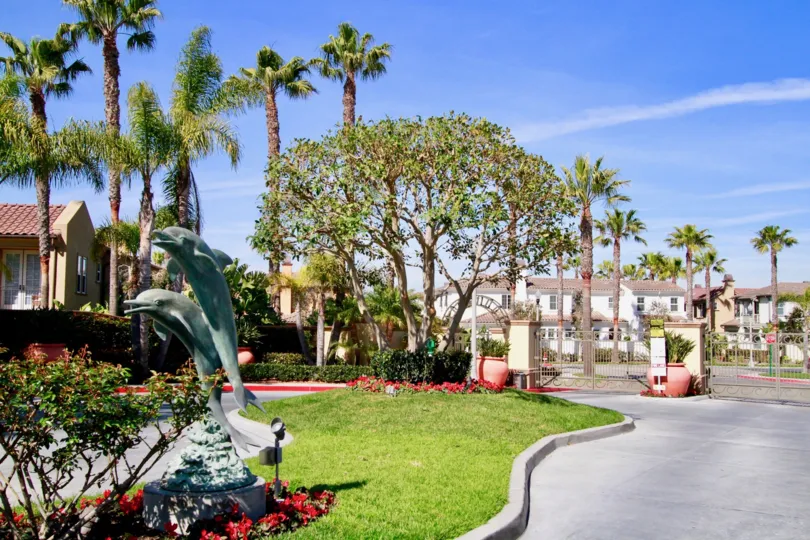 THE PLACE LOOKS LIKE A BEAUTIFUL GARDEN WITH FISH STATUE AND SOME PLANTS LOOKING GOOD WITH DIFFERENT COLOURS AND A BUILDING ALSO NEAR TO THE PLACE.