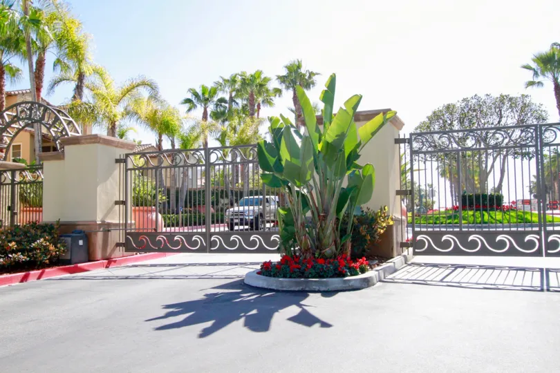 The Waterfront gate with palm trees and flowers on a sunny day.
