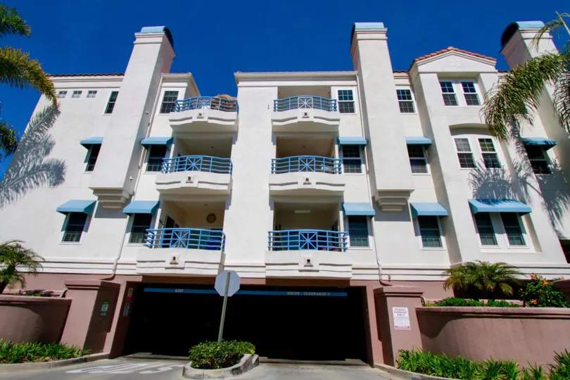 Condominiums located above a garage with well kept landscaping and nice paint.