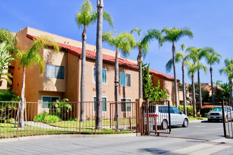 Villa St. Croix apartments with palm trees and gate on a sunny day.