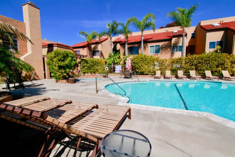 A sunny day in the Villa St. Croix with swimming pool, chairs and trees.