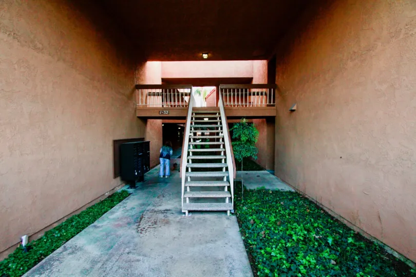 Staircase in a Villa Warner building with mailboxes and a tree.