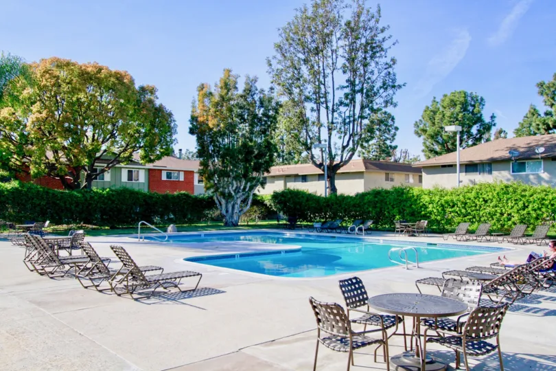 A sunny day in the Village Townhomes with swimming pools and lots of trees and plants.