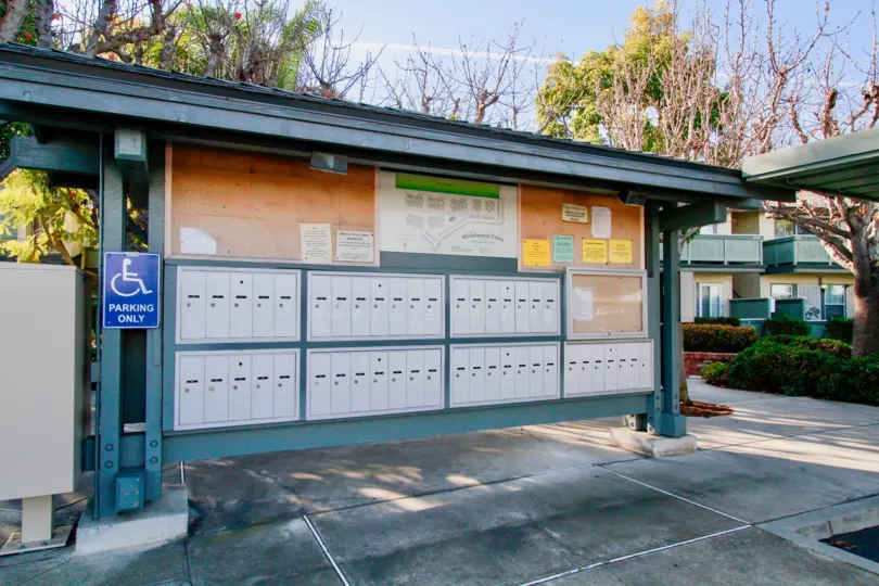 Windward Cove bulletin area with mailboxes and map on a sunny day.