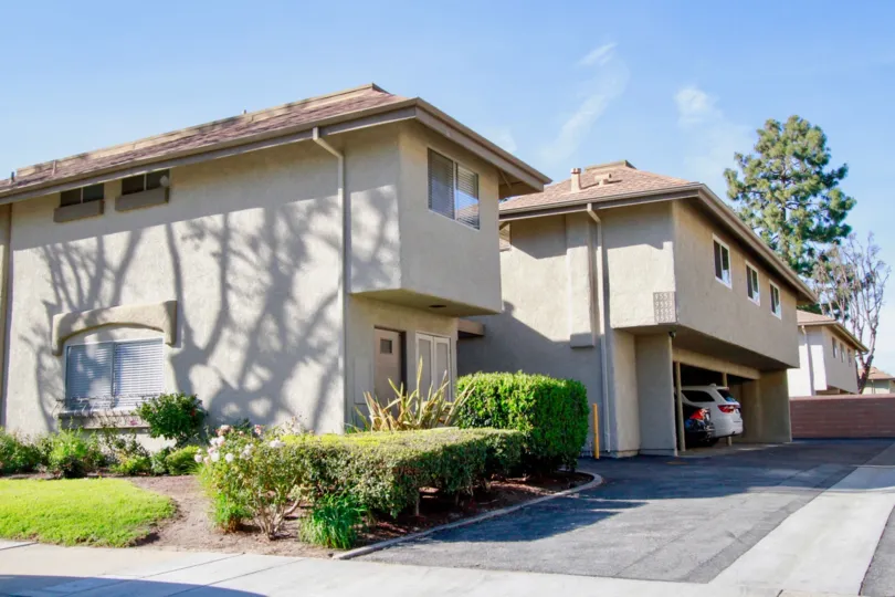 The homes in the Yorktown Villas with trees, plants, cars and also with carparking.
