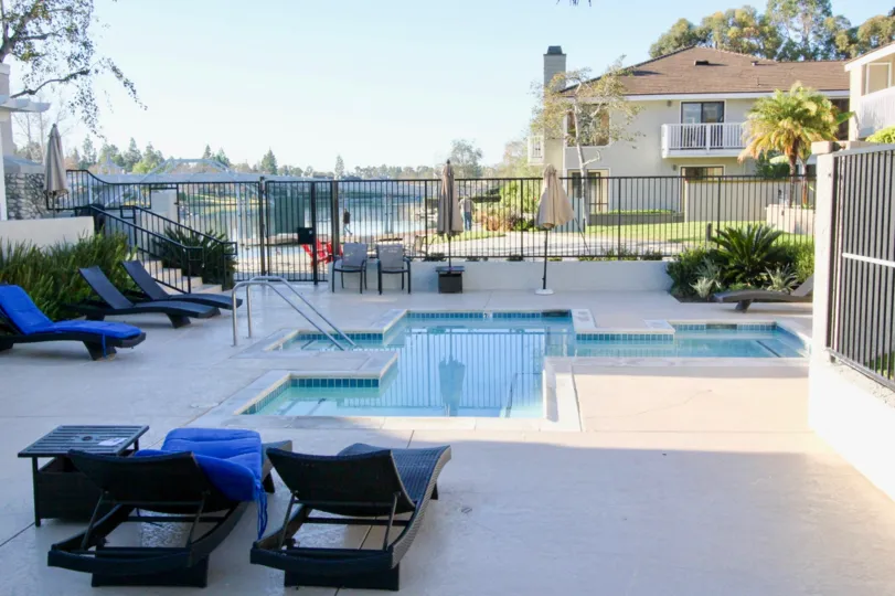 THE HOME IN THE ARBORLAKE WITH THE SWIMMING POOL, CHAIRS, PLANTS, TREES