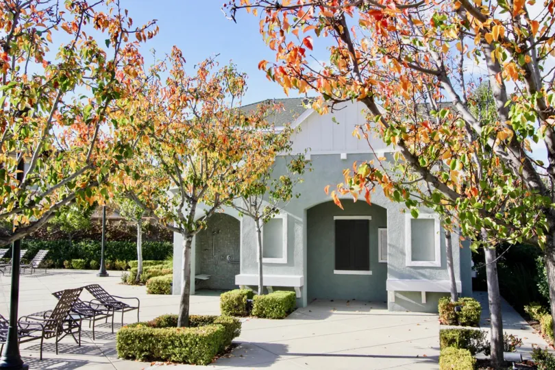 A large gray building with trees surrounded by hedges inside Arden Square in irvine CA