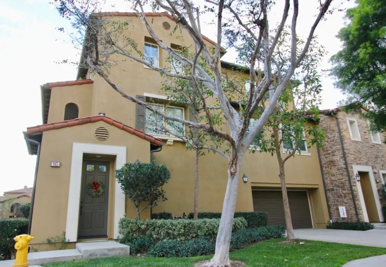 THE LARGE HOUSE WITH TREES, PLANTS, LAWN, DOOR NUMBER ARE SHOWN IN THE CITY OF IRVINE
