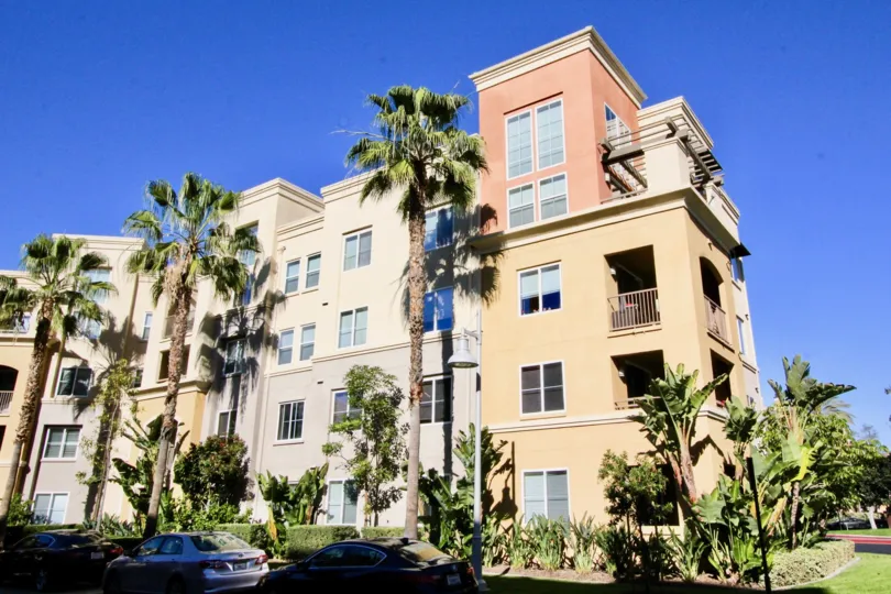 THE APARTMENT WHICH IS IN IRVINE, THAT SHOWS THE GLASS WINDOWS, LOT OF TREES, PLANTS