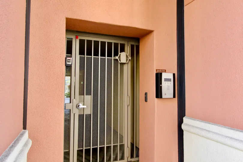 Silver security door at pink entry way at Avenue One in Irvine CA