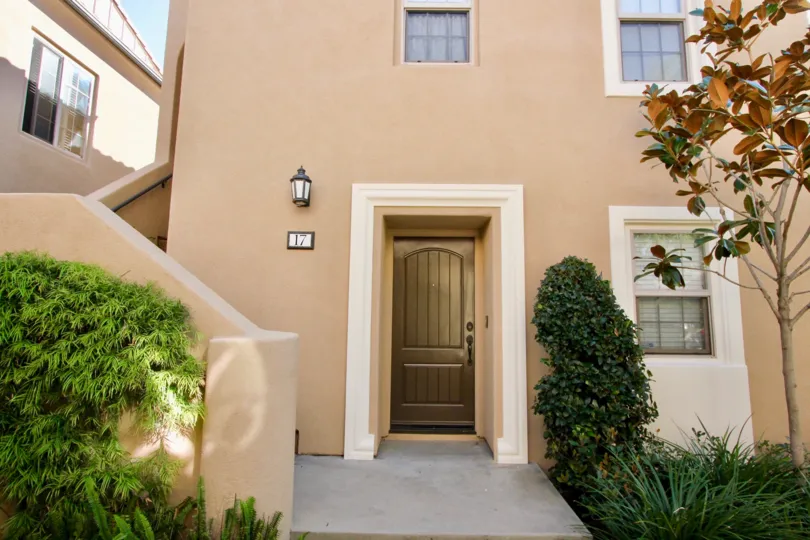 THE ENTRANCE OF THE HOME WITH PLANTS, TREES, NEARBY STEPS, LAMP ARE THERE IN THE CITY OF IRVINE
