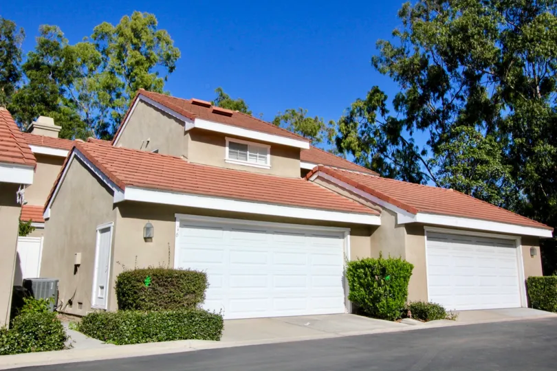 Town homes with attached garages near a driveway at Cambridge Court in Irvine CA