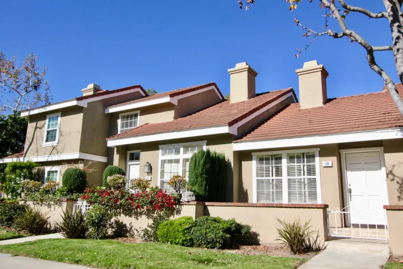 Three town homes with chimneys and front yards inside Cambridge Court in Irvine California