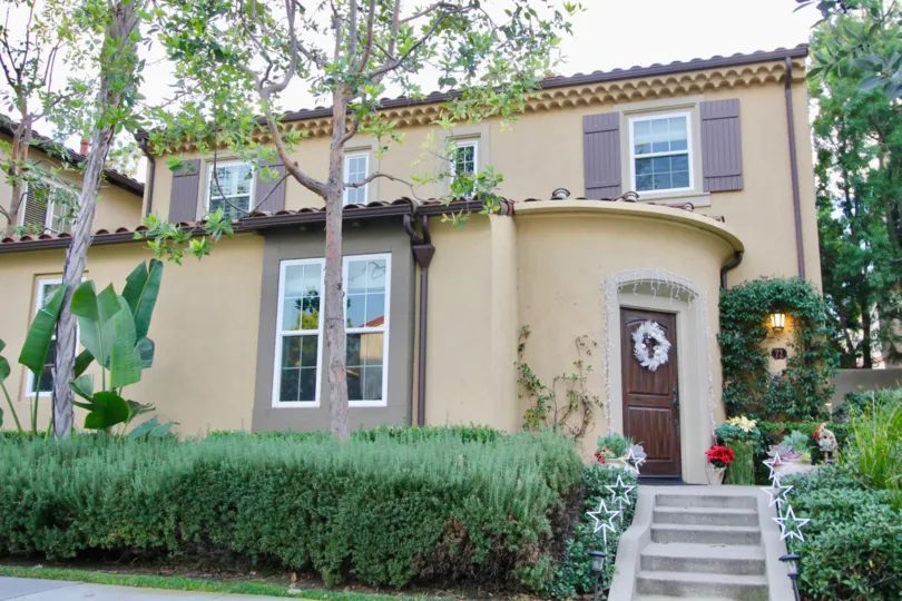 THE ENTRANCE WAY TO THE HOME WHICH SHOWS THE PLANTS, TREES, GLASS WINDOWS, STEPS, LAMP LIGHTS ARE THERE IN THE IRVINE CITY