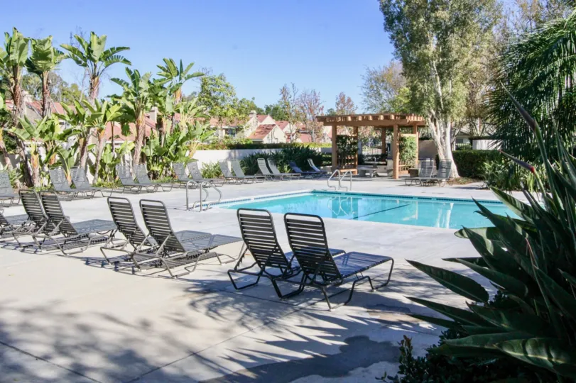 A blue rectangle pool with lawn chairs located in Columbia Square in Irvine CA