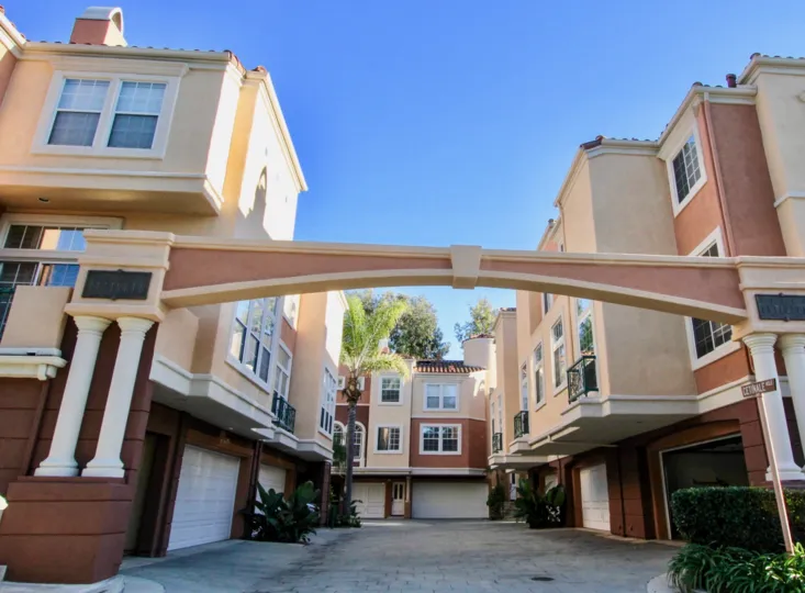 An arched courtyard in the Corte Bella community surrounded by three-storey houses.