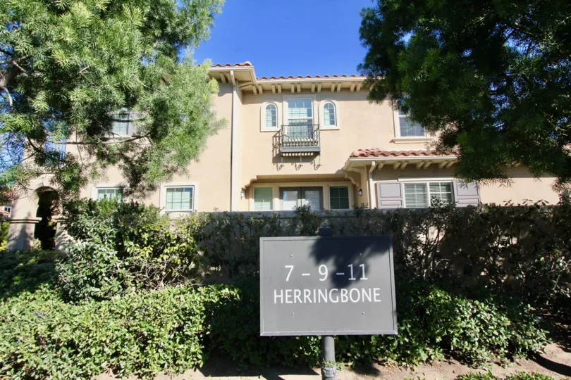 THE FRONT VIEW OF HOUSE WITH NAME BOARD WHICH IS SITUATED IN IRVINE, THAT VIEWS LOT OF PLANTS, AND TREES