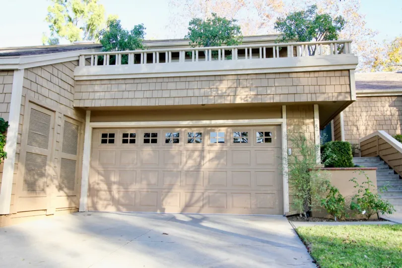 A brick home with attached garage and stairs inside Glen Garden Homes in Irvine CA