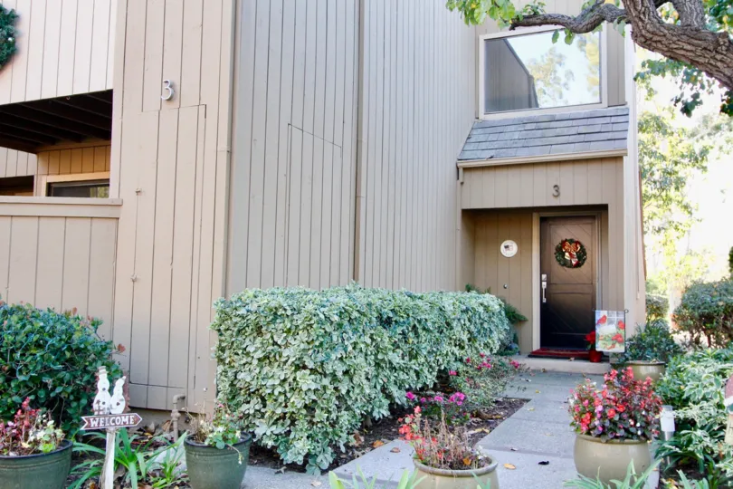 A two story home with a single large window above a black front door at Glen Townhomes in Irvine CA
