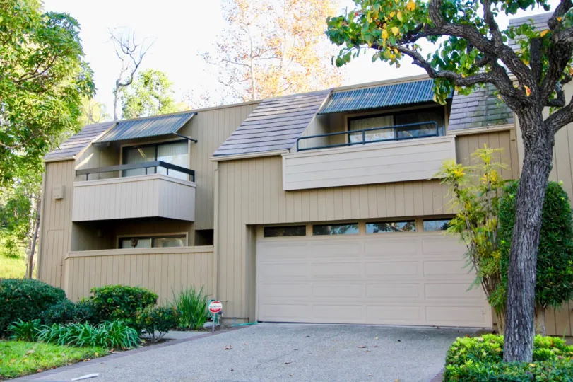 a warn day in the glen townhomes with building that has roofless top and parking door closed in the left side