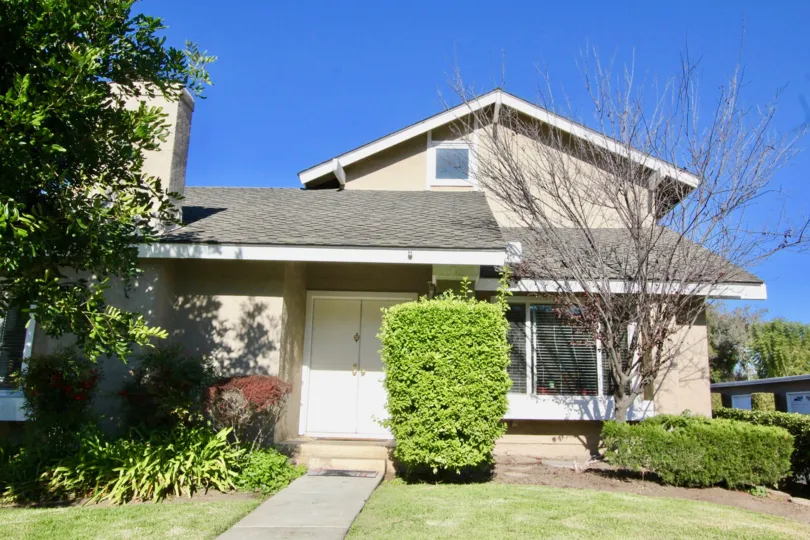 THIS SHOWS THE FRONT OF THE HOME WITH TREES AND PLANTS WHICH IS IN IRVINE CITY