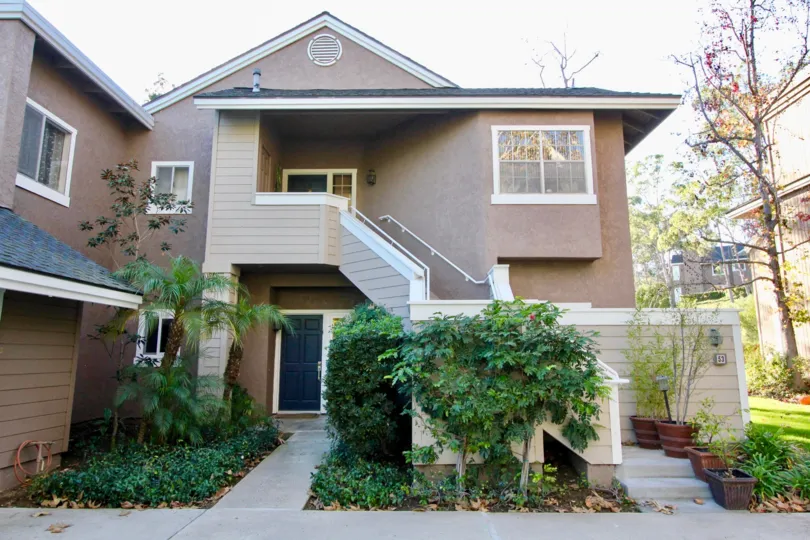 A sunny day in Highland View with a large house with trees and potted plants surrounding it