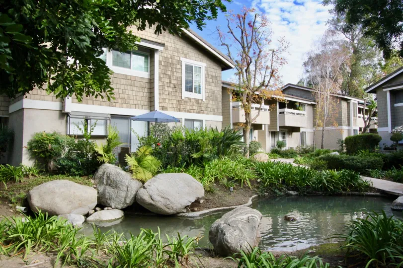 An adorable water filled pond with giant rocks inside Irvine Springs in Irvine California