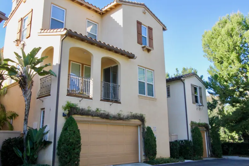 a warm day in the lvy wreath with house that has roofless top and parking of sandle door closed in front