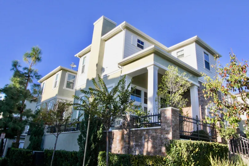 THE SIDEVIEW OF LARGE HOUSE WITH THE PLANTS, TREES SURROUNDED THE WALL IS IN THE IRVINE CITY